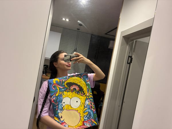 Mirror selfie showing off a framed Bart Simpson painting.