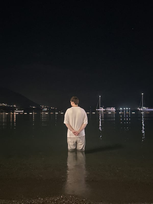 Person stands in nighttime waters off Budva Montenegro coast