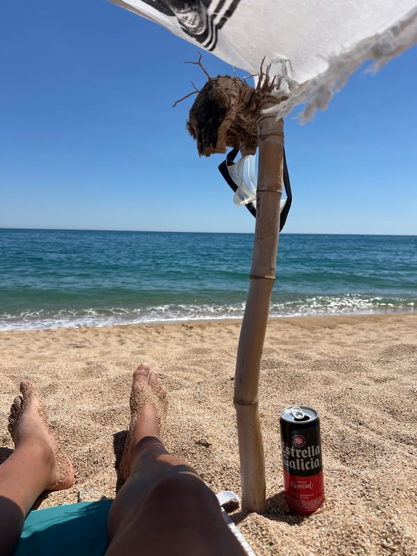 Beachgoer enjoys sunny afternoon with beer in Sant Pol de Mar