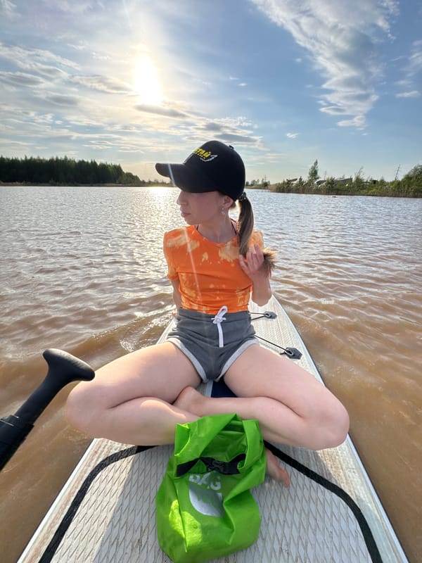 Woman paddleboards on muddy waters in Noviy, Russia