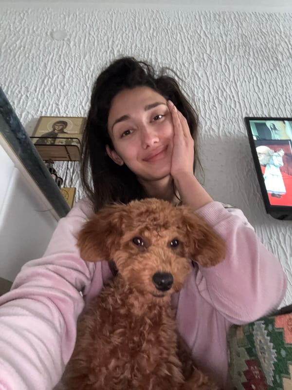 Woman relaxes at home with poodle, takes selfies