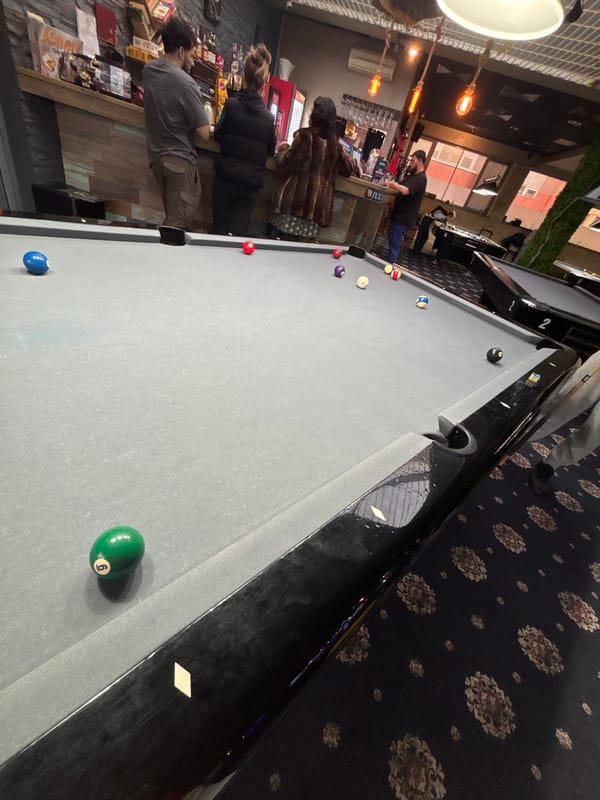 Patrons gather around pool table at Plovdiv bar