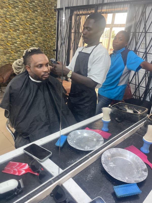 Routine barbershop session documented in Jos, Nigeria