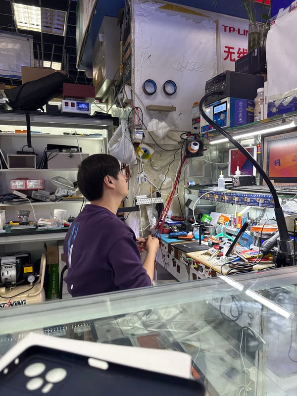 Technician works in cluttered electronics repair shop, Haidian District