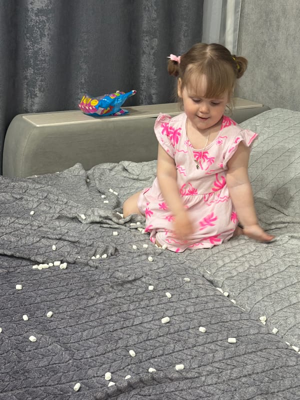 Toddler in pink dress plays indoors in Chaikovsky