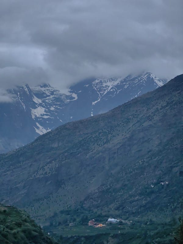 Keylong under heavy cloud, mountains and town in dim light