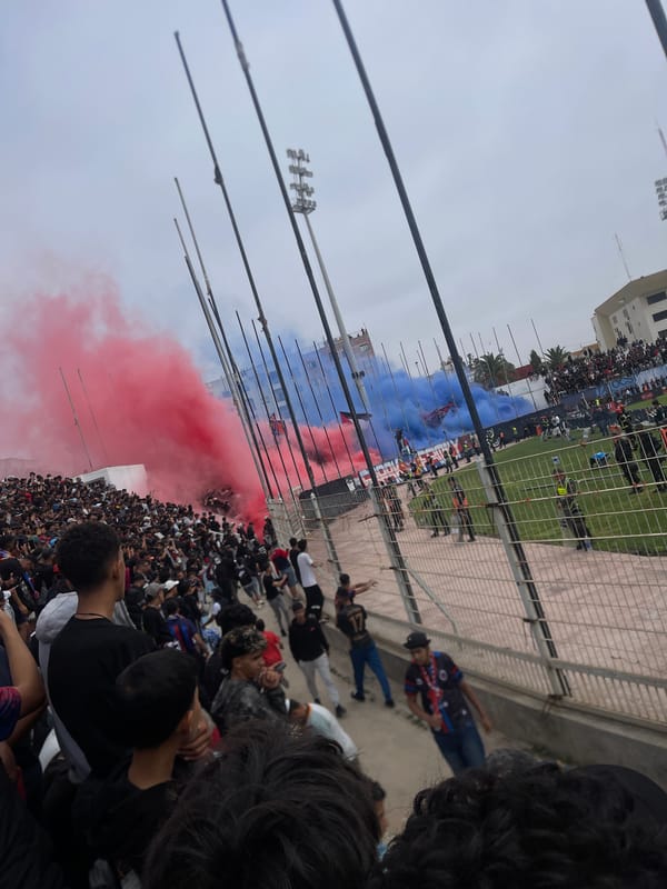 Football fans gather with flags and flares at Safi stadium