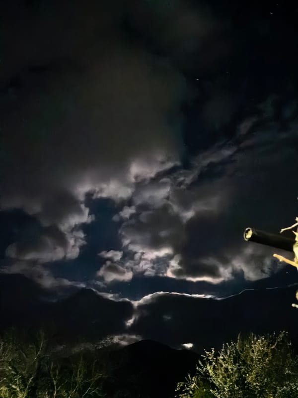 Nighttime moonlit scenes captured across mountainous terrain with city lights