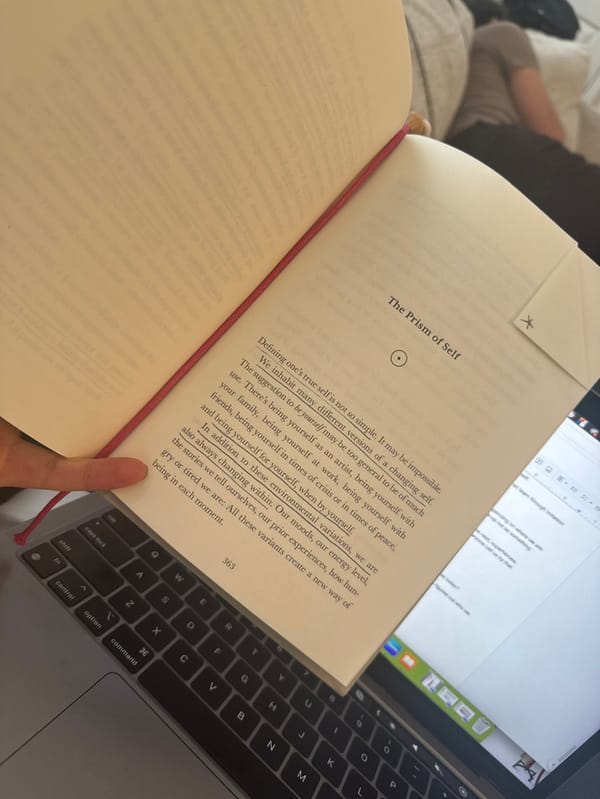 Person reads book over laptop keyboard in NYC