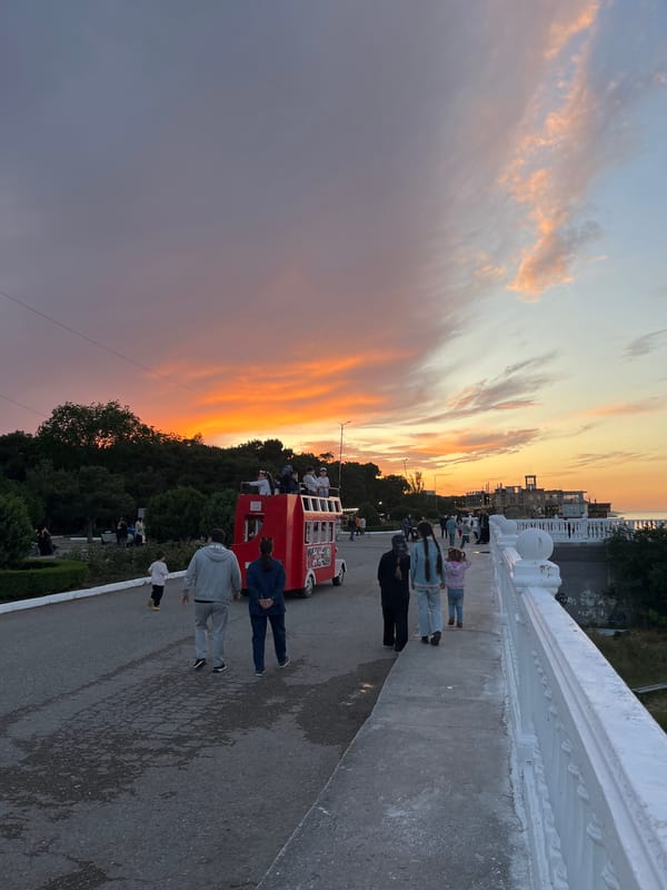 Evening stroll captured on Kaspiysk waterfront bridge at sunset
