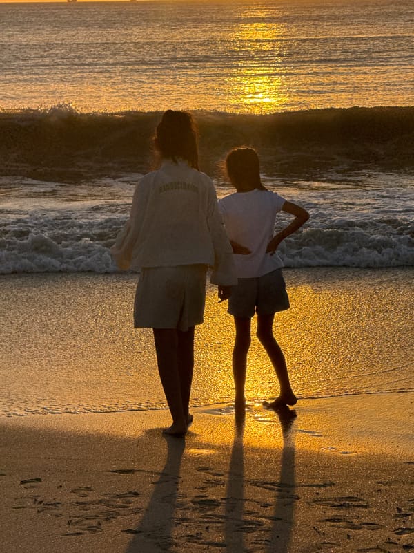 Golden hour on a Kuta Selatan beach, group gathered at the shore