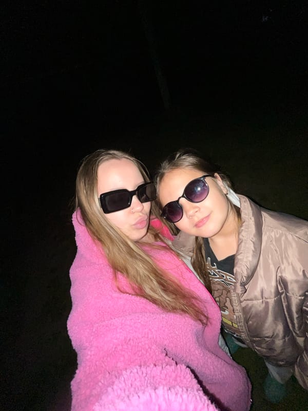 Young women pose for nighttime photos in Novopokrovskaya