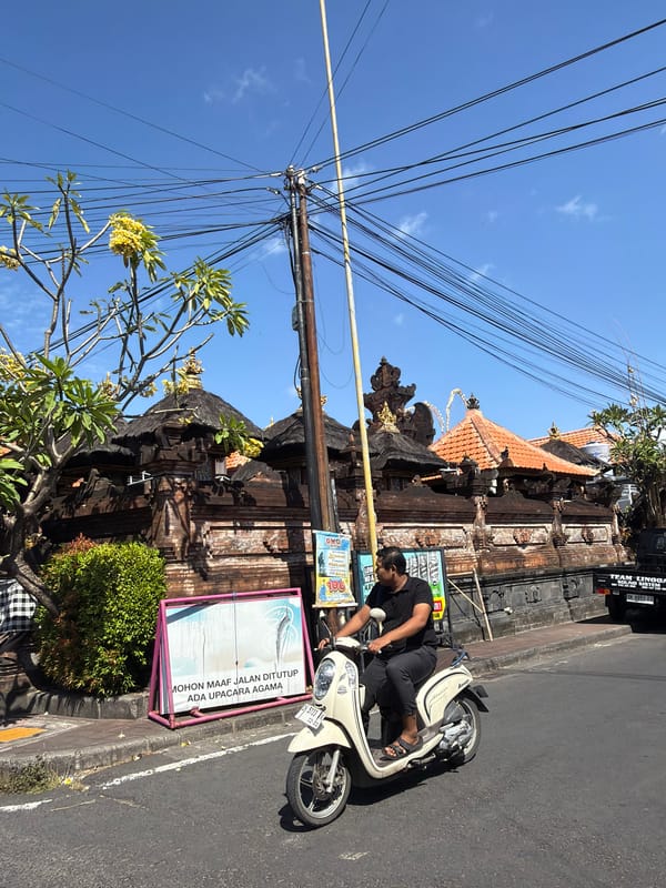 Everyday street life alongside Balinese temples and ceremonial decor