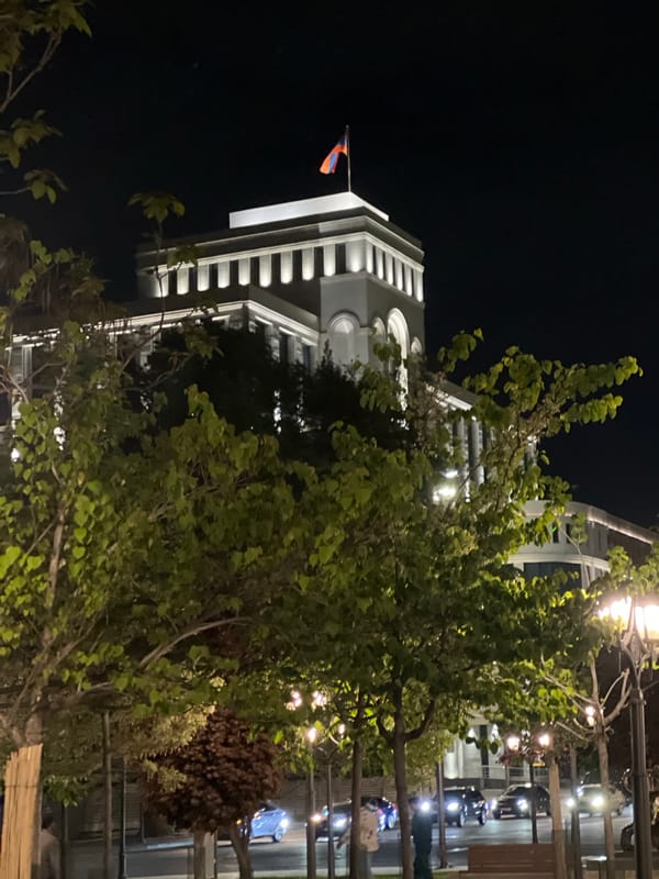 Illuminated government building with Armenian flag observed in Yerevan