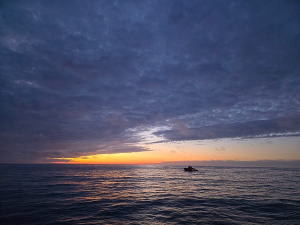 Boat observed on ocean during dramatic sunset