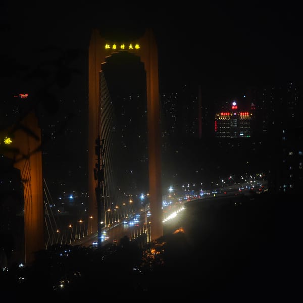 Illuminated Hongyan Village Bridge displays Chinese characters at night