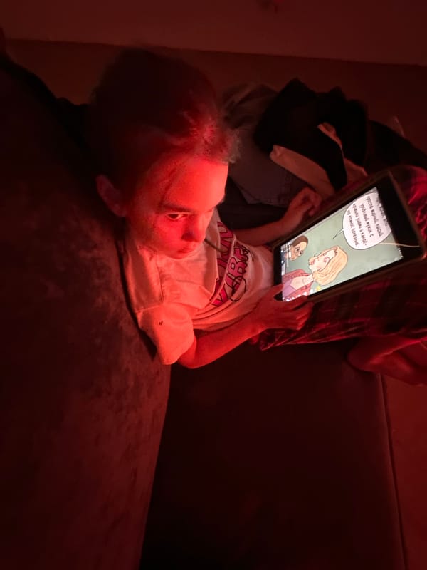 Child watches tablet cartoons on couch in Kharnavy, Russia