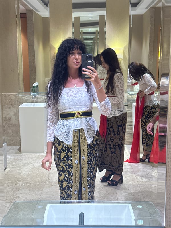 Woman in traditional kebaya takes selfies in Kuta Selatan