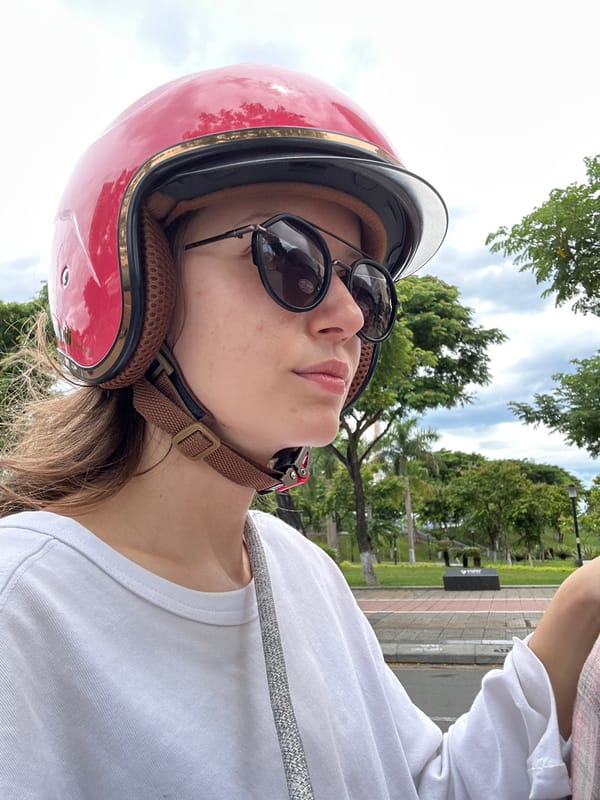 Scooter rider on a cloudy Đà Nẵng street, July morning