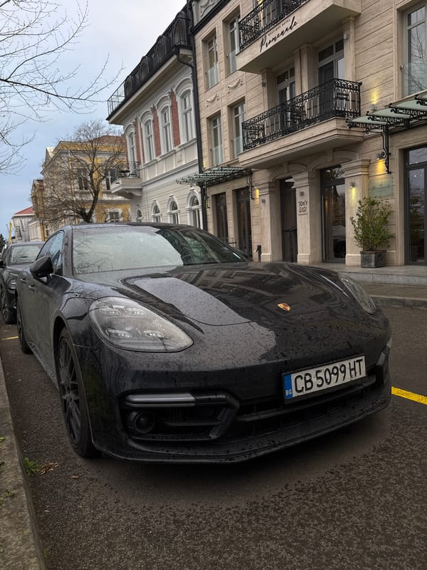 Person poses with luxury cars on rainy Burgas street