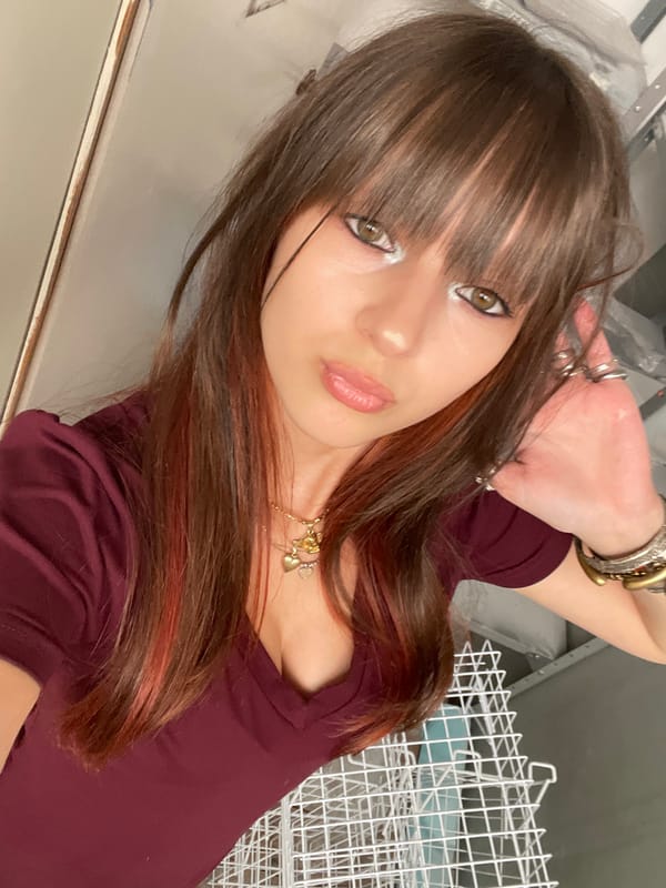 Woman takes selfies in maroon shirt in Raanana