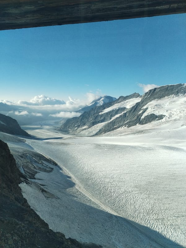 Snow-covered glacier valley flanked by jagged mountain peaks