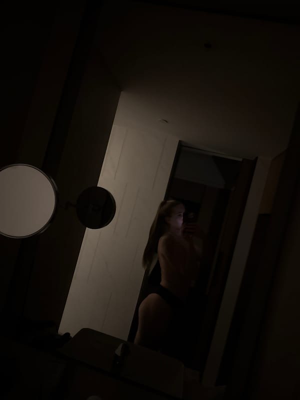 Person uses phone in bed in dimly lit Zhangjiajie room