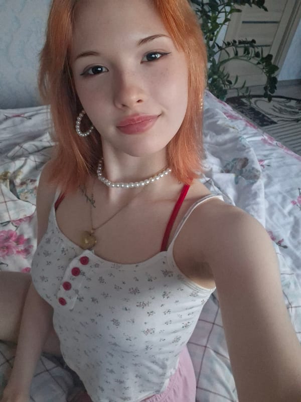 Woman takes playful selfies in bedroom in Chaikovsky