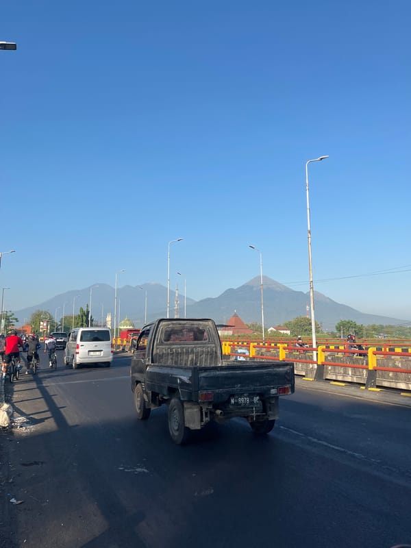 Cyclists and motorcyclists share a bridge route in East Java