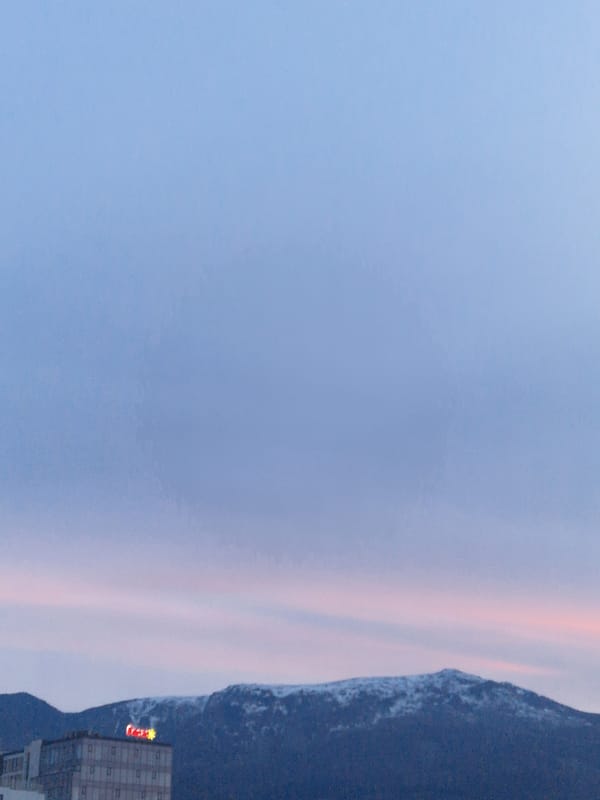 Twilight cityscape with pink horizon captured by witness