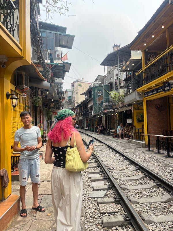 Train tracks intersect narrow Hanoi street scene