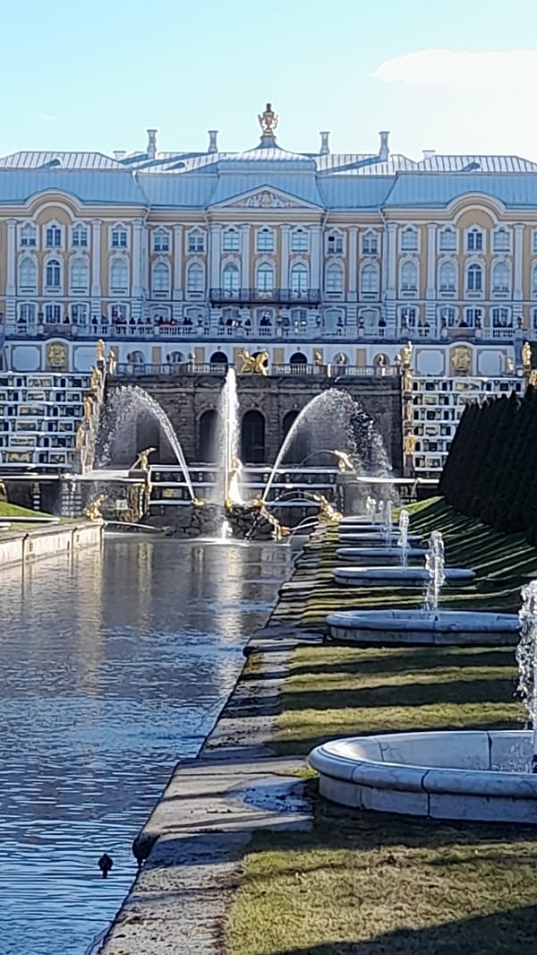Visitors document Peterhof Palace fountains and bronze statue