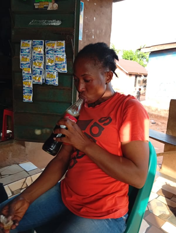 Woman enjoys Coke and meal at outdoor shop