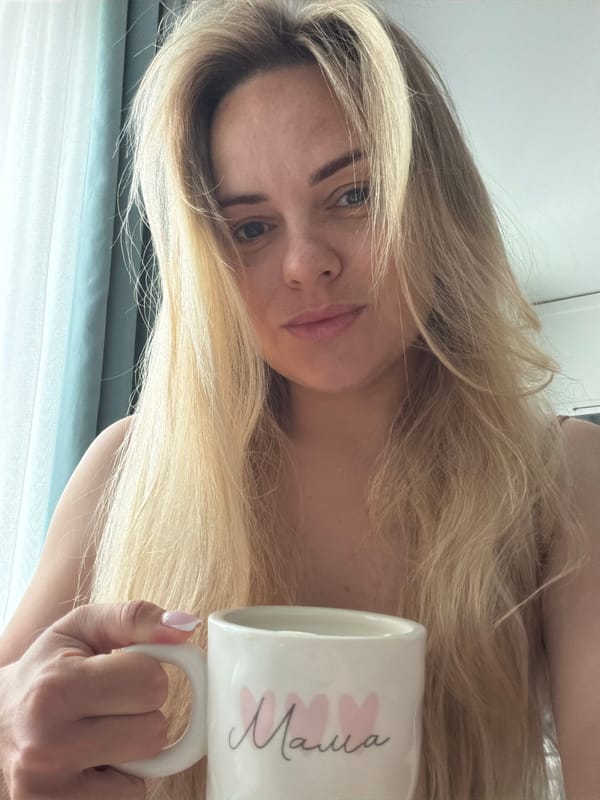 Woman holds 'Mama' mug during quiet morning moment in Votkinsk