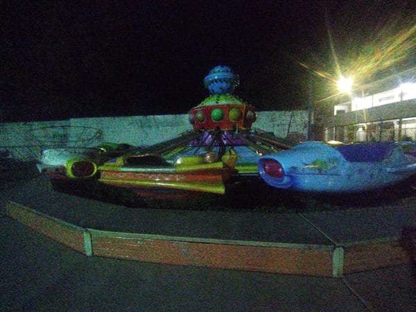 Nighttime carnival attractions observed with colorful rides and decorations