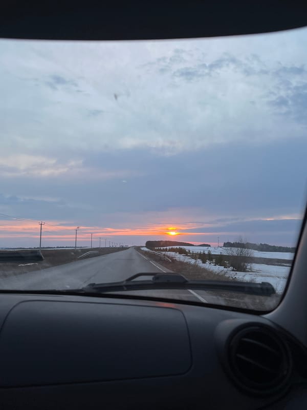 Sunset view captured from vehicle on snowy Russian road