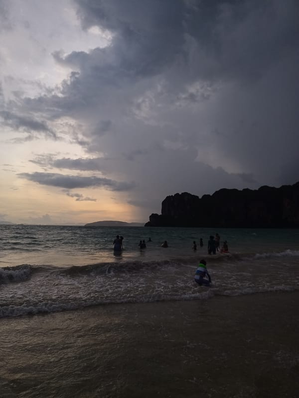 Tourists enjoy dramatic sunset at Ban Ao Nang beach