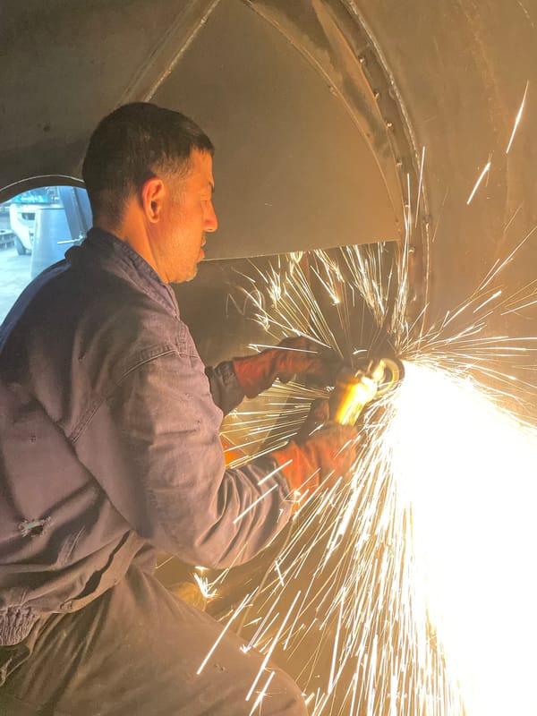 Worker operates angle grinder inside metal structure in Montenegro