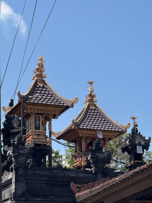 Ornate multi-tiered Balinese temple towers against clear blue sky