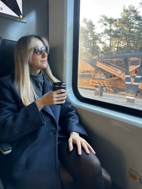 Morning commuter with coffee observes construction from Riga train