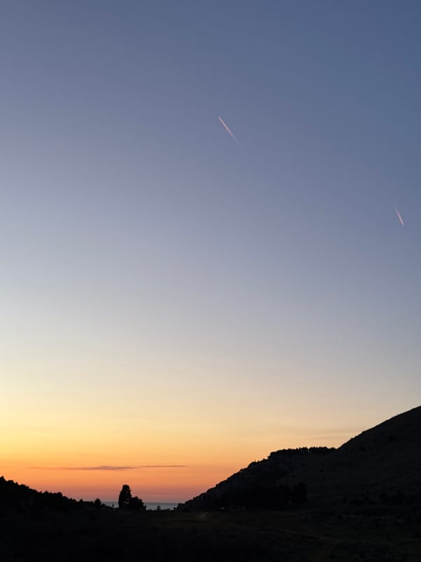 Aircraft contrails observed over Montenegro countryside during spring afternoon