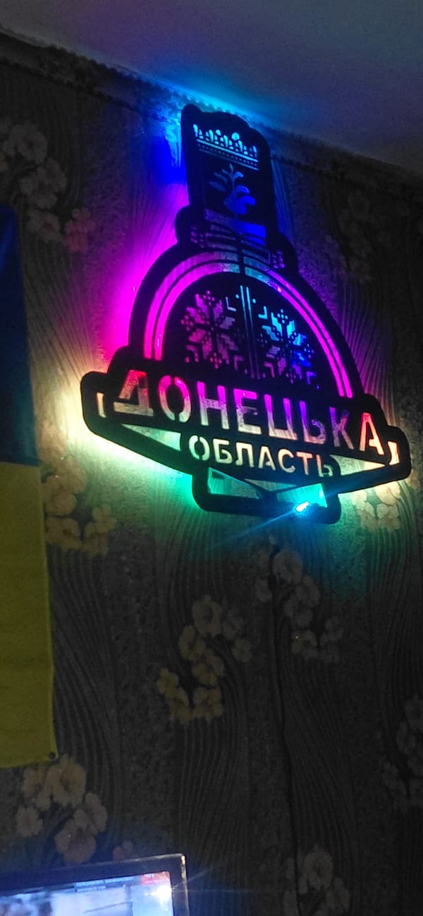 Inside a Ketrysanivka building with Donetsk Oblast signage, late evening