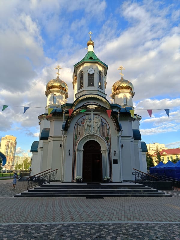 White and gold Orthodox church dressed with festive flags