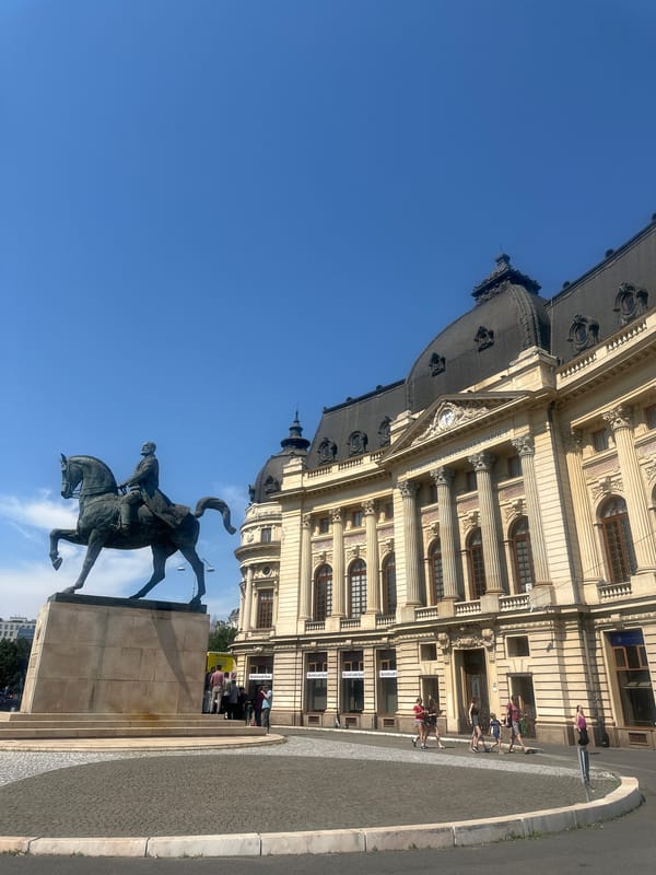 Equestrian monument outside a neoclassical building on a clear day