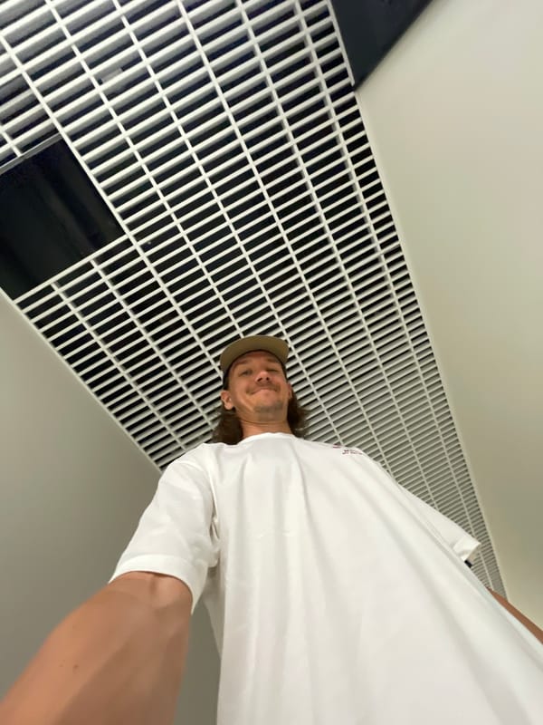 Man takes selfies in Izhevsk hallway with green bag