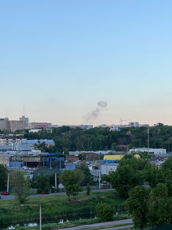 Ring-shaped smoke column observed over city skyline during evening