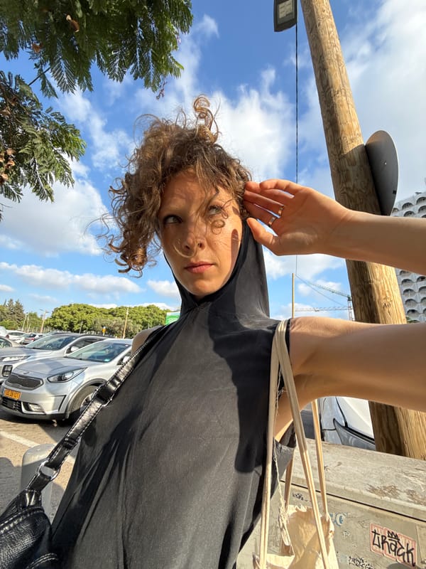 Pausing on a Tel Aviv street, hand to ear