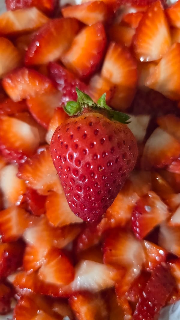 Person prepares fresh strawberries in food preparation scene