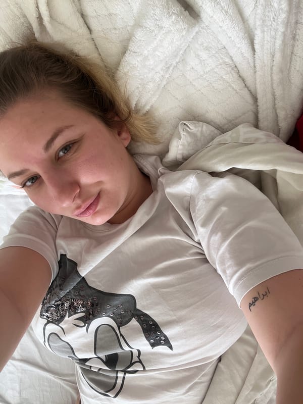 Woman in Mickey Mouse shirt rests on bed