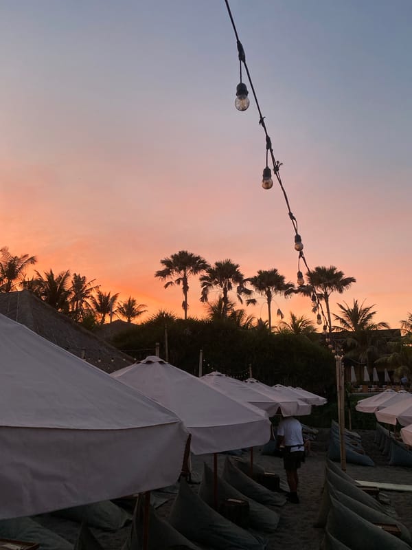 Sunset colors fade over North Kuta's dark sand beach.